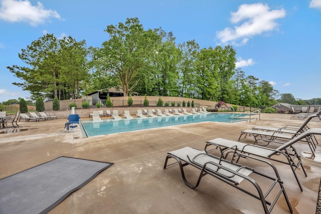 community pool with fence and a patio area
