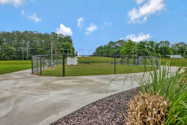 view of property's community with fence and concrete driveway