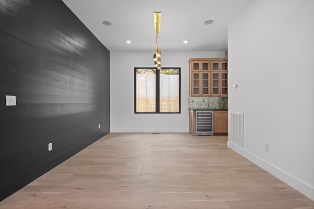 1608 Knickerbocker Ave, Chattanooga, TN 37405 - unfurnished living room with wine cooler, a bar, light wood-style floors, recessed lighting, and baseboards