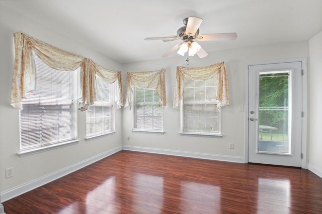unfurnished room with wood finished floors, baseboards, and a ceiling fan