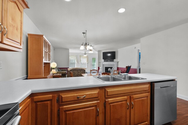 kitchen featuring stainless steel dishwasher, open floor plan, a sink, a fireplace, and light countertops