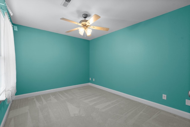 spare room with carpet, ceiling fan, and baseboards