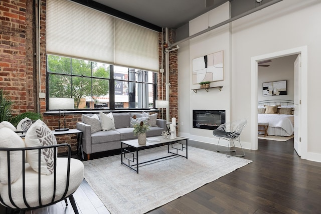 1301 Market St Unit 103, Chattanooga, TN 37402 - living room featuring wood finished floors, brick wall, a glass covered fireplace, and baseboards