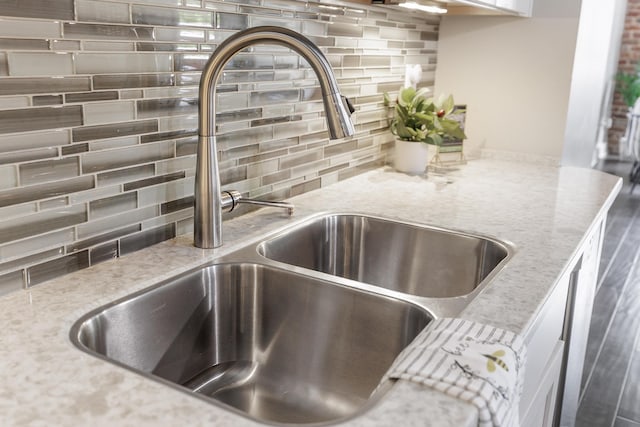 1301 Market St Unit 103, Chattanooga, TN 37402 - kitchen view of a sink, tasteful backsplash, and light stone counters
