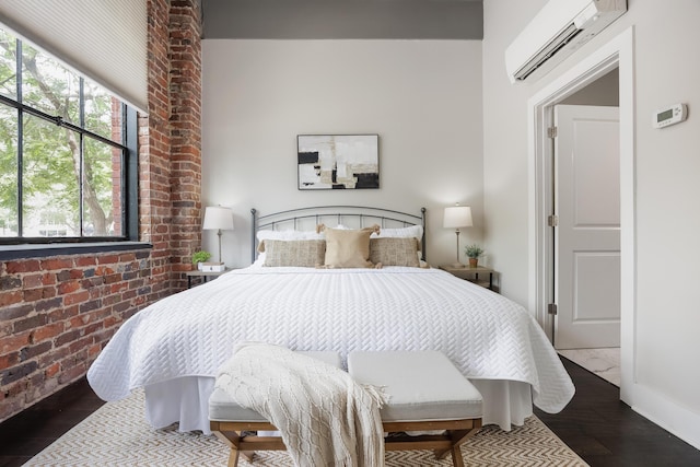 1301 Market St Unit 103, Chattanooga, TN 37402 - bedroom featuring a wall unit AC, wood finished floors, brick wall, and baseboards