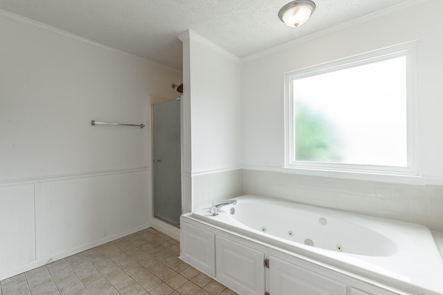 bathroom featuring a stall shower, a tub with jets, wainscoting, crown molding, and a textured ceiling
