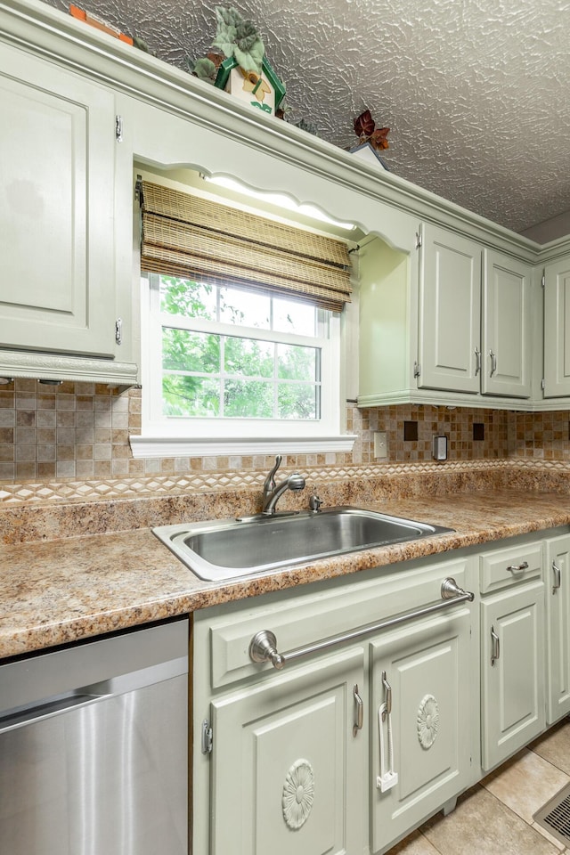 kitchen with dishwasher, a sink, backsplash, and light countertops