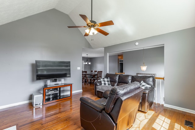 living area featuring baseboards, ceiling fan, hardwood / wood-style floors, and high vaulted ceiling