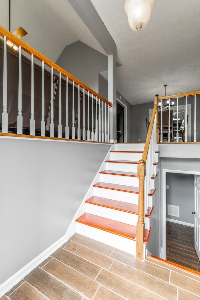 stairway featuring wood finish floors and baseboards