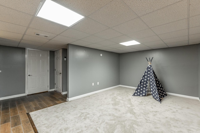 playroom with baseboards, a drop ceiling, and wood finished floors