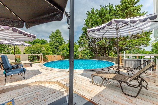 view of swimming pool featuring a deck and fence