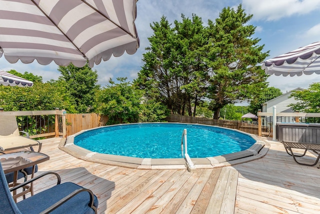 view of pool featuring a fenced backyard and a deck