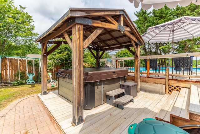 wooden deck with a hot tub, a fenced backyard, and a gazebo