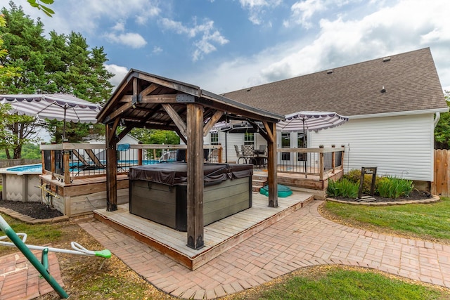view of patio with a gazebo, a hot tub, a deck, an outdoor pool, and fence