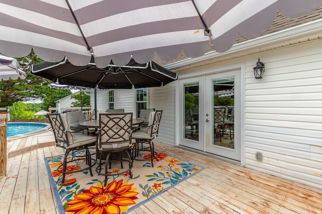 deck featuring outdoor dining space, french doors, and an outdoor pool