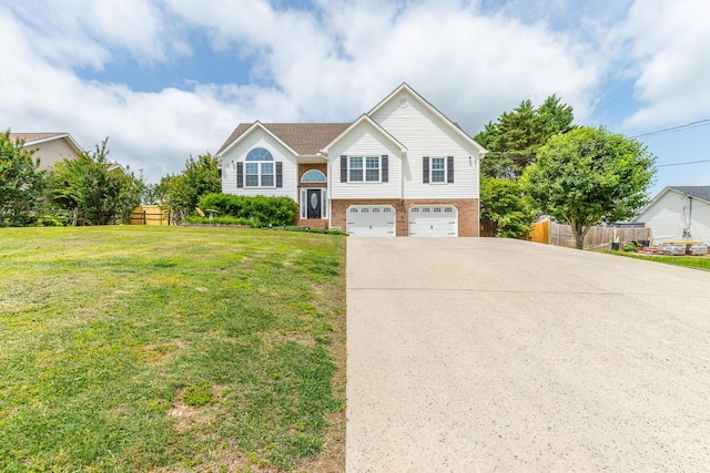 bi-level home with an attached garage, driveway, and brick siding