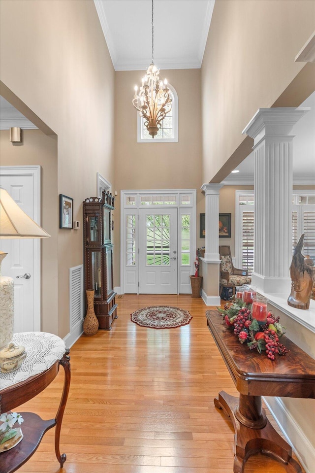 362 Windmill Ln, Georgetown, TN 37336 - entryway featuring decorative columns, a towering ceiling, light wood-style flooring, a chandelier, and ornamental molding
