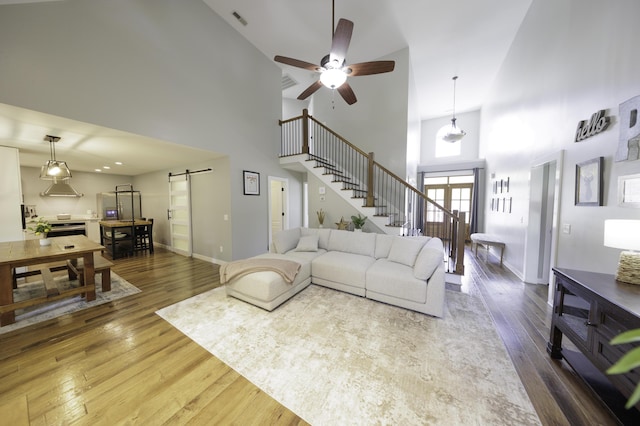5611 Caney Ridge Cir, Ooltewah, TN 37363 - living room with a barn door, a high ceiling, stairway, wood-type flooring, and ceiling fan