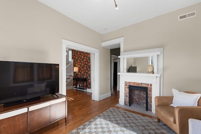 709 S Holly St, Chattanooga, TN 37404 - living room featuring a fireplace with flush hearth, stairs, wood finished floors, and baseboards