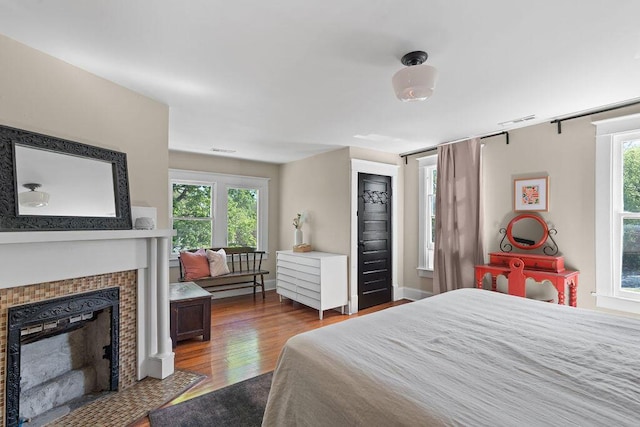 709 S Holly St, Chattanooga, TN 37404 - bedroom with multiple windows, wood finished floors, and a tiled fireplace