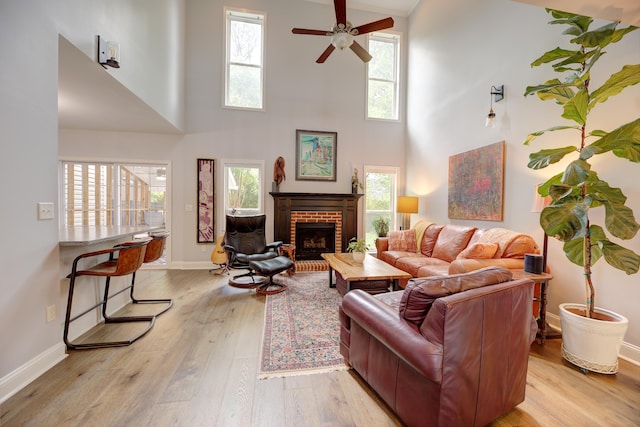 7830 Legacy Park Ct, Chattanooga, TN 37421 - living room featuring a high ceiling, light wood-type flooring, ceiling fan, a fireplace, and baseboards