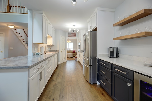 7830 Legacy Park Ct, Chattanooga, TN 37421 - kitchen featuring freestanding refrigerator, beverage cooler, white cabinetry, wood finished floors, and a chandelier
