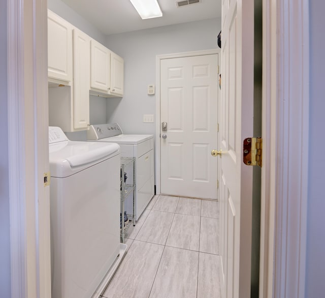7830 Legacy Park Ct, Chattanooga, TN 37421 - laundry area featuring washing machine and clothes dryer, cabinet space, and light tile patterned flooring