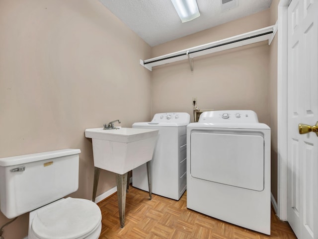 216 Longview Dr, Rossville, GA 30741 - laundry area featuring washing machine and dryer, a textured ceiling, and baseboards