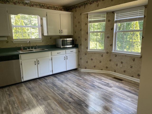 6206 Sagefield Dr, Harrison, TN 37341 - kitchen with appliances with stainless steel finishes, wallpapered walls, a sink, wood finished floors, and white cabinets