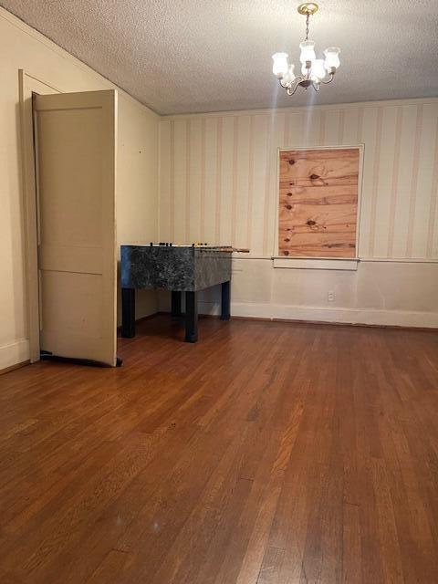 4908 13th Ave, Chattanooga, TN 37407 - unfurnished dining area featuring dark wood-style floors, a chandelier, and a textured ceiling
