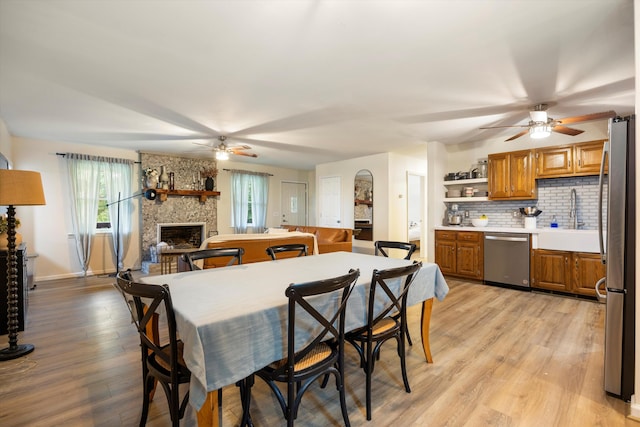 142 Holli Bird Ln, Ringgold, GA 30736 - dining room featuring ceiling fan, a fireplace, light wood-style floors, and baseboards