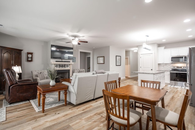 8647 Kensley Ln, Hixson, TN 37343 - dining area with a ceiling fan, light wood-type flooring, a fireplace, recessed lighting, and baseboards