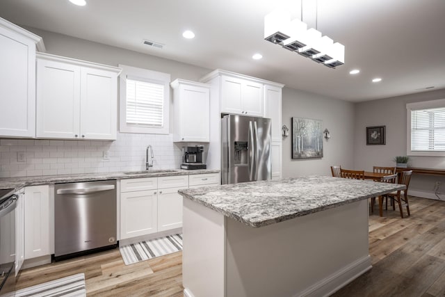 8647 Kensley Ln, Hixson, TN 37343 - kitchen with appliances with stainless steel finishes, a sink, light wood-style flooring, tasteful backsplash, and recessed lighting