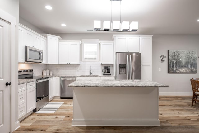 8647 Kensley Ln, Hixson, TN 37343 - kitchen featuring appliances with stainless steel finishes, a sink, tasteful backsplash, recessed lighting, and a kitchen island
