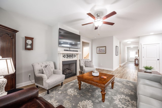 8647 Kensley Ln, Hixson, TN 37343 - living area with a fireplace, a ceiling fan, light wood-style floors, and baseboards