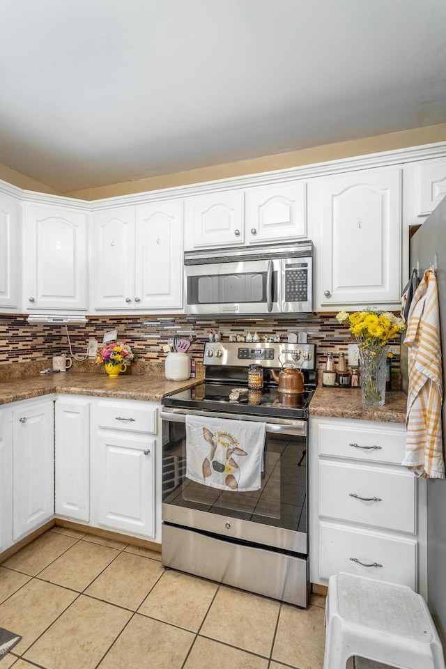 647 Peachtree Cir, Ringgold, GA 30736 - kitchen with appliances with stainless steel finishes, light tile patterned floors, decorative backsplash, and white cabinetry