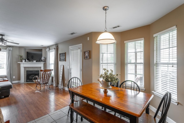 647 Peachtree Cir, Ringgold, GA 30736 - dining area with a tiled fireplace, a ceiling fan, tile patterned flooring, and baseboards