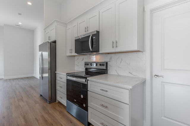 1384 Unity Dr NE, Cleveland, TN 37312 - kitchen with appliances with stainless steel finishes, decorative backsplash, wood finished floors, white cabinets, and recessed lighting