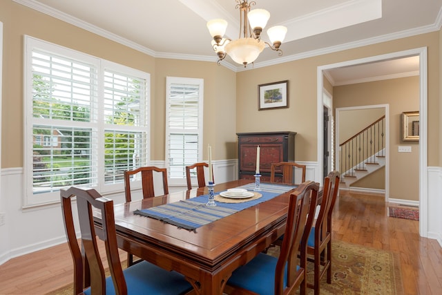 6063 Heritage Ridge Dr, Hixson, TN 37343 - dining room featuring light wood-style floors, a chandelier, crown molding, stairs, and wainscoting
