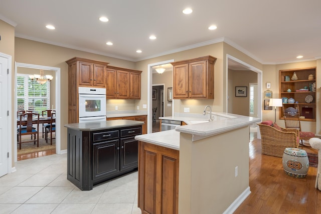 6063 Heritage Ridge Dr, Hixson, TN 37343 - kitchen featuring a chandelier, a sink, white double oven, a peninsula, and recessed lighting