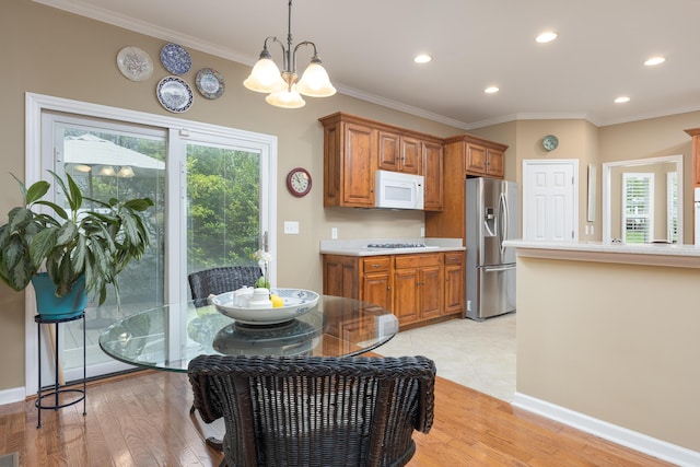 6063 Heritage Ridge Dr, Hixson, TN 37343 - kitchen with white microwave, stainless steel refrigerator with ice dispenser, brown cabinets, light countertops, and a chandelier