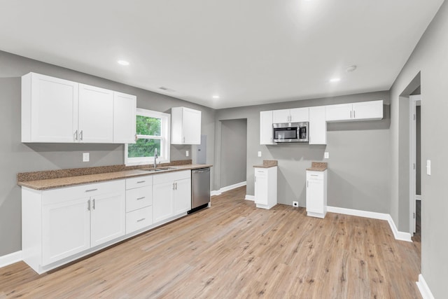 1904 Sharp St, Chattanooga, TN 37404 - kitchen with stainless steel appliances, a sink, light wood finished floors, white cabinetry, and recessed lighting