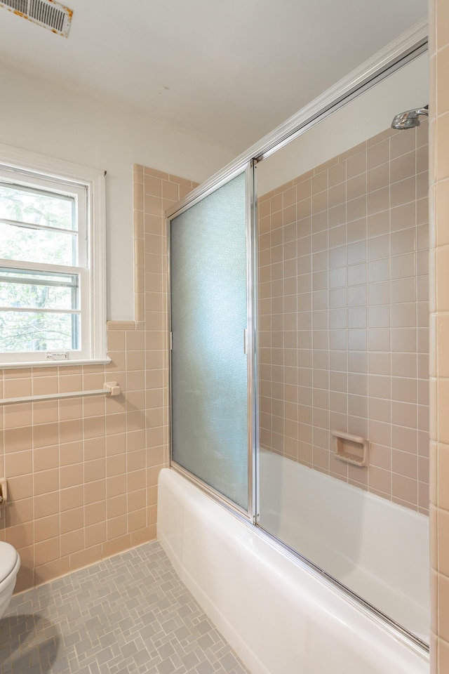1613 Fairy Dell Trl, Lookout Mountain, GA 30750 - bathroom featuring toilet, bath / shower combo with glass door, and tile walls