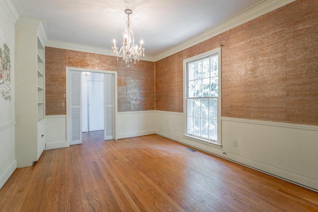 1613 Fairy Dell Trl, Lookout Mountain, GA 30750 - spare room featuring a wainscoted wall, a chandelier, wood finished floors, and ornamental molding