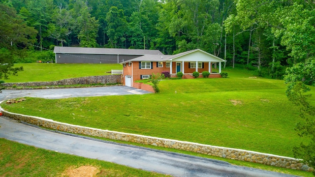 5873 Old Dayton Pike, Chattanooga, TN 37415 - view of front facade featuring asphalt driveway, a porch, a forest view, a garage, and a front yard