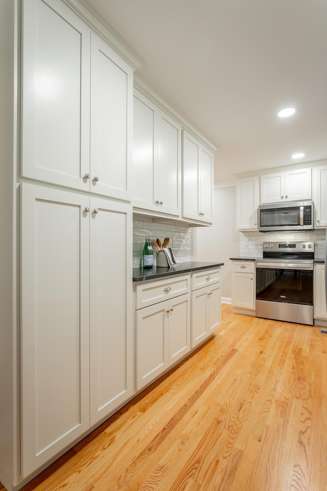 5873 Old Dayton Pike, Chattanooga, TN 37415 - kitchen featuring appliances with stainless steel finishes, decorative backsplash, light wood finished floors, dark countertops, and white cabinetry