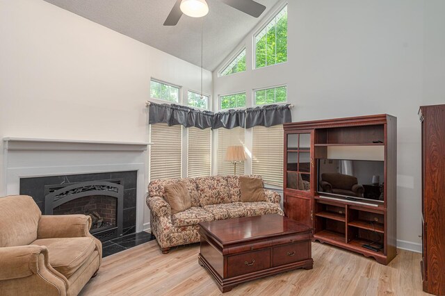 2418 Charleston Sq, Chattanooga, TN 37421 - living room with high vaulted ceiling, ceiling fan, light wood finished floors, a tiled fireplace, and baseboards