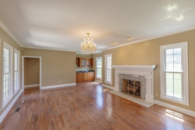 7902 Ooltewah Georgetown Rd, Ooltewah, TN 37363 - unfurnished living room featuring a chandelier, baseboards, wood finished floors, a high end fireplace, and ornamental molding