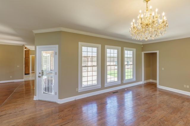 7902 Ooltewah Georgetown Rd, Ooltewah, TN 37363 - spare room featuring plenty of natural light, a chandelier, wood finished floors, baseboards, and ornamental molding