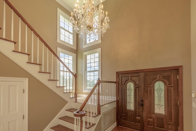 7902 Ooltewah Georgetown Rd, Ooltewah, TN 37363 - entrance foyer featuring a high ceiling, stairs, a chandelier, healthy amount of natural light, and crown molding